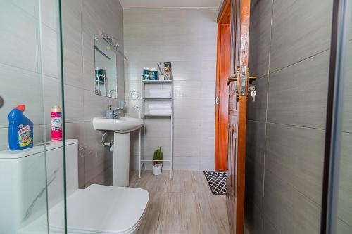 a small bathroom with a toilet and a sink at Macgregor Apartment in Nairobi