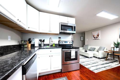 a kitchen with white cabinets and a living room at Redwood loft at Park Place King bed walk in closet fast WIFI and free coffee in Wilmington