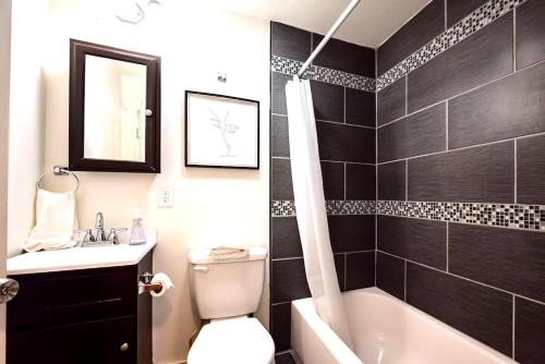 a bathroom with a tub and a toilet and a sink at Redwood loft at Park Place King bed walk in closet fast WIFI and free coffee in Wilmington