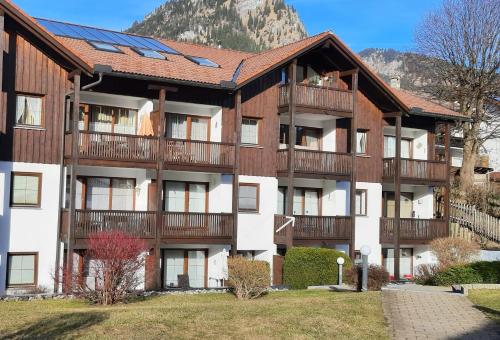 an apartment building with balconies and a mountain in the background at Almstube in Bad Hindelang