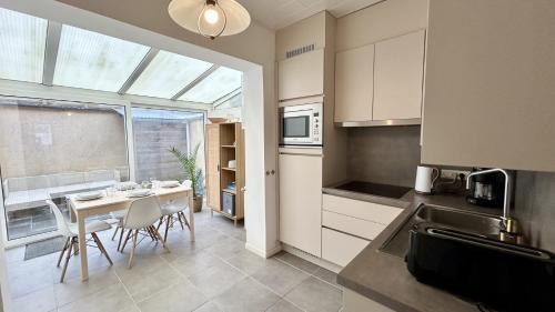 une cuisine avec une table et des chaises dans une cuisine dans l'établissement L'Ecume, au Crotoy