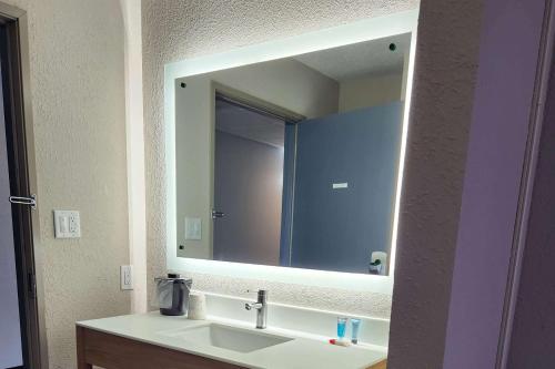 a bathroom with a sink and a large mirror at Days Inn by Wyndham Davenport in Davenport