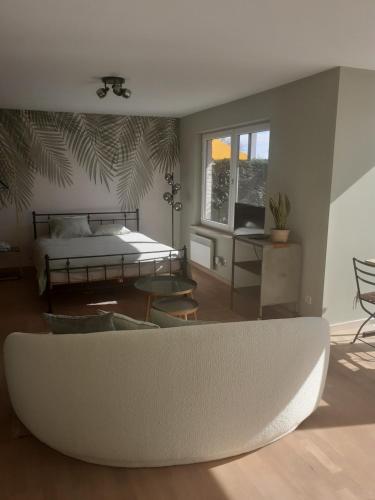 ein Wohnzimmer mit einem weißen Sofa und einem Bett in der Unterkunft Home Away in Blankenberge