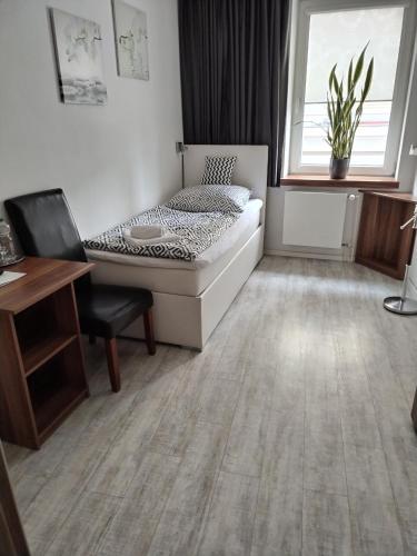 a bedroom with a bed and a desk and a window at Hotel Na Baste in Jablonec nad Nisou