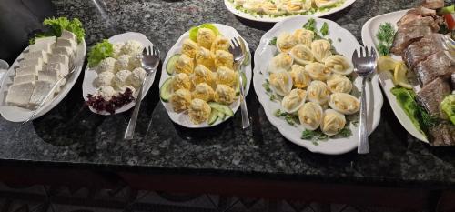a bunch of plates of food on a table with forks at Hotel Wodnik Twój Hotel z widokiem na morze in Ustronie Morskie