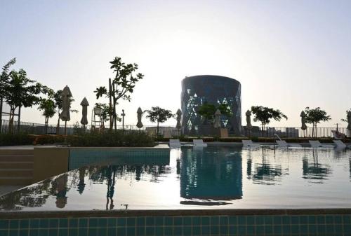 a swimming pool with a fountain in front of a building at Dubai Hills Collective Tower 2 in Dubai