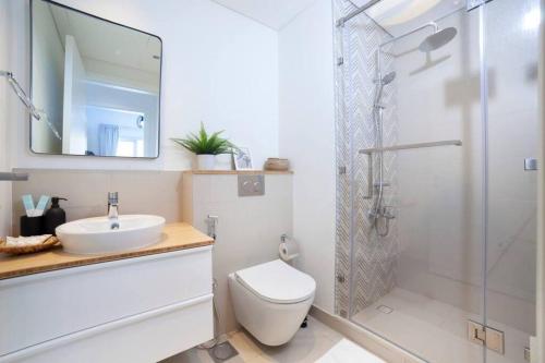 a bathroom with a toilet and a sink and a shower at Dubai Hills Collective Tower 2 in Dubai