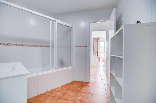 een witte badkamer met een douche en een wastafel bij Puerto Marina, Apartamento Frente al mar in Benalmádena