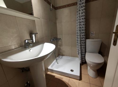 a bathroom with a sink and a toilet at Paraliako katerina Studios & Rooms - Biker Friendly Hotel in Kastoria
