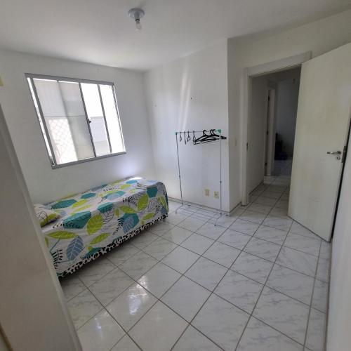 a living room with a bed and a window at Quarto in Maceió