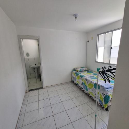 a small bedroom with a bed and a mirror at Quarto in Maceió