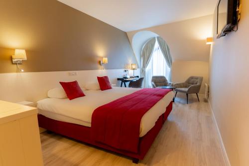 a bedroom with a large bed with a red blanket at Hotel Acacia in Bruges