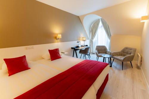 a bedroom with a large bed with red pillows at Hotel Acacia in Bruges