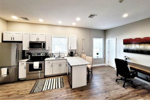 a kitchen with white cabinets and a table and a stove at The Penthouse at Park Place King bed fast WIFI and free coffee in Wilmington