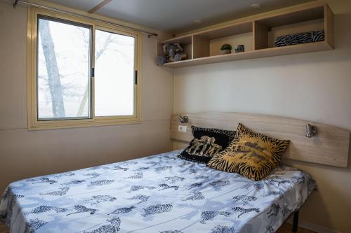 ein Schlafzimmer mit einem Bett mit Kissen darauf in der Unterkunft Tóparti Safari-ház a Richter Safari Parkban in Nagykőrös