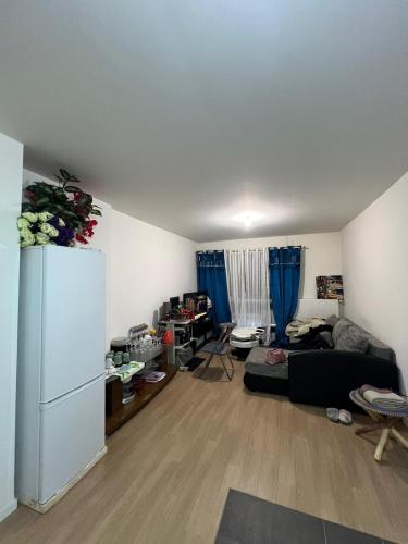 ein Wohnzimmer mit einem Kühlschrank und einem Sofa in der Unterkunft Havre de paix in Noisy-le-Roi