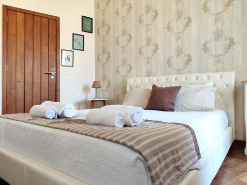 - une chambre avec un grand lit blanc et des serviettes dans l'établissement Vintage Place - Azorean Guest House, à Ponta Delgada