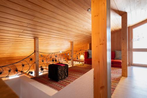 Cette chambre dispose d'un plafond en bois et d'une valise. dans l'établissement Ferienhaus Casa Chapf, à Amden