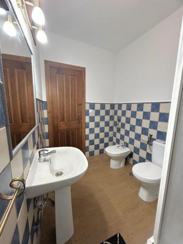 a bathroom with a sink and a toilet and a mirror at LA CUADRA in Gaucín