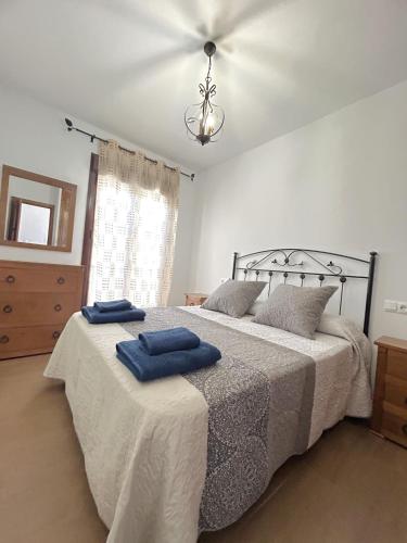 a bedroom with a bed with two blue towels on it at LA CUADRA in Gaucín