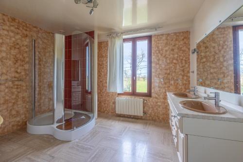 a large bathroom with two sinks and a shower at Les Grandes Landes - Piscine privée - Grand jardin in Cricqueville-en-Bessin