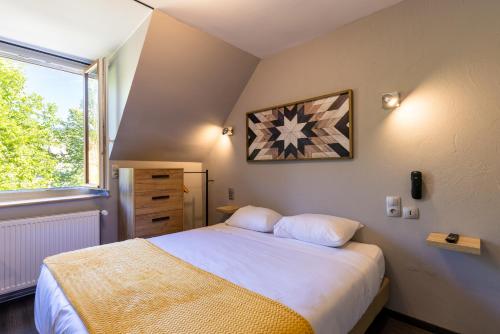 a bedroom with a large bed and a window at Auberge de la Rivière in Foncine-le-Haut