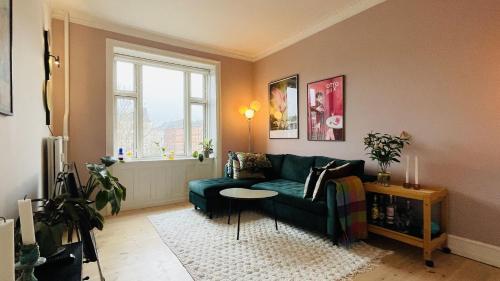 a living room with a green couch and a table at ApartmentInCopenhagen Apartment 1593 in Copenhagen