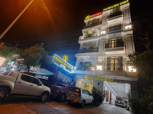 a building with cars parked in front of it at night at NAM CẦN THƠ HOTEL in Ấp Phú Thạnh (4)