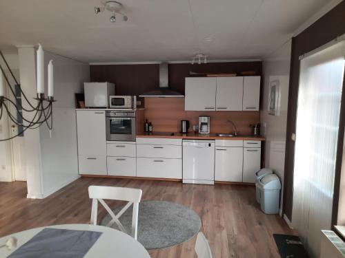 a kitchen with white cabinets and a table and a chair at Ferienhaus-Landliebe-Wohnung-9048-3 in Dänschendorf