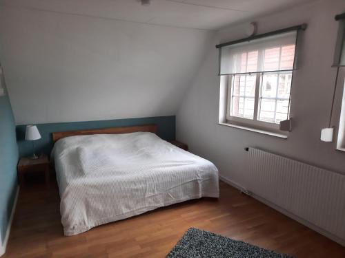 ein Schlafzimmer mit einem weißen Bett und einem Fenster in der Unterkunft Ferienhaus Landliebe, Wohnung 9048-3 in Dänschendorf