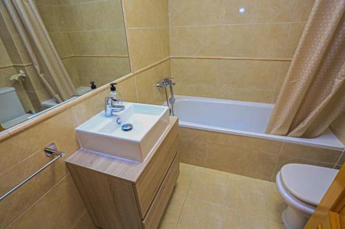 a bathroom with a sink and a tub and a toilet at Casa de vacaciones LAS CUMBRES - ONLY FAMILIES in Salou