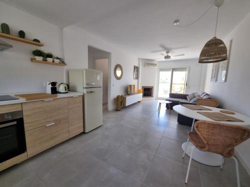 Una cocina y una sala de estar con refrigerador y una mesa. en Calahonda Royale Penthouse with Sea Views, en Cabopino