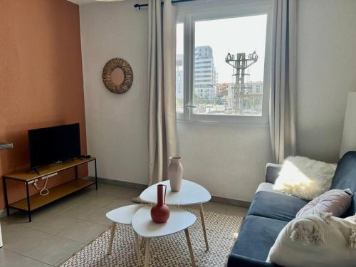 un salon avec un canapé bleu et deux tables dans l'établissement Studio Saint-Roch, à Montpellier