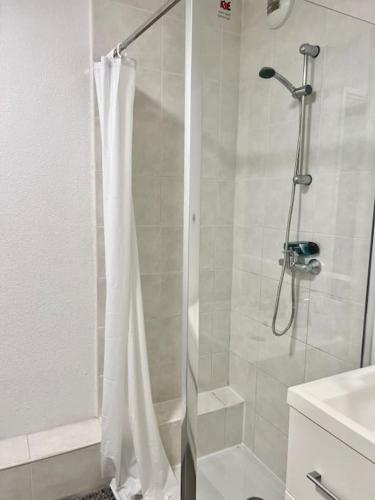 La salle de bains est pourvue d'une douche avec un rideau de douche blanc. dans l'établissement Studio Saint-Roch, à Montpellier