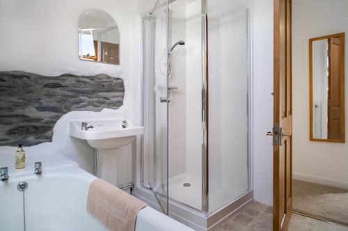 a bathroom with a shower and a tub and a sink at Garden Cottage Newcastle Emlyn in Newcastle Emlyn