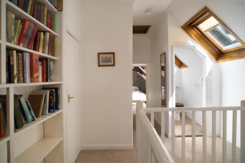 a hallway with bookshelves and a staircase with a door at Garden Cottage Newcastle Emlyn in Newcastle Emlyn