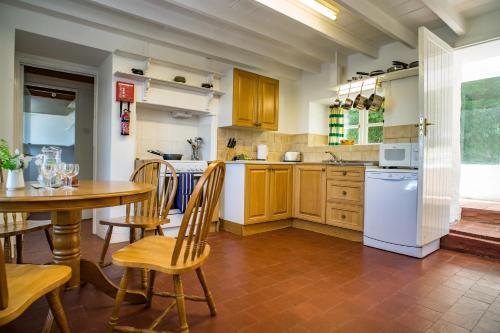 a kitchen with a table and a white refrigerator at Garden Cottage Newcastle Emlyn in Newcastle Emlyn