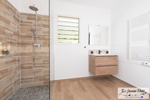 a bathroom with a shower and a sink at Meublé de tourisme " Le Jasmin Étoilé"- Hell-Bourg - SALAZIE in Salazie