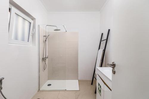 a white bathroom with a shower and a sink at Bright and Spacious Two Bedroom Apt in Almada in Almada