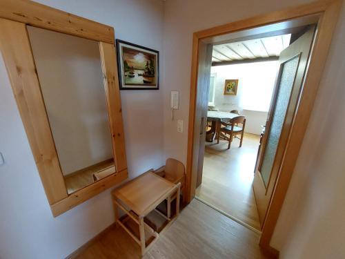 a room with a mirror and a chair and a table at Ferienwohnung Jäger in Viereth-Trunstadt