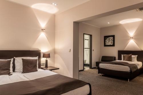 ein Hotelzimmer mit 2 Betten und einem Stuhl in der Unterkunft Mauritius Hotel & Therme in Köln