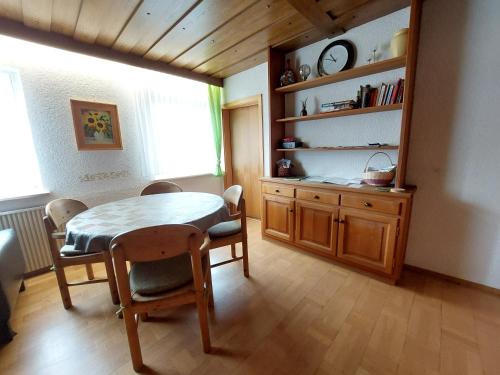 a dining room with a table and chairs and a shelf at Ferienwohnung Jäger in Viereth-Trunstadt