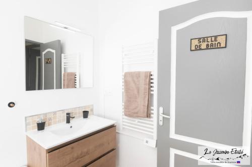 ein Bad mit einem Waschbecken und einem Spiegel in der Unterkunft Meublé de tourisme " Le Jasmin Étoilé"- Hell-Bourg - SALAZIE in Salazie
