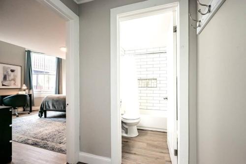 a bathroom with a toilet and a window at The Grayson at Park Place- cozy and fully updated with King bed free coffee and fast WIFI in Wilmington
