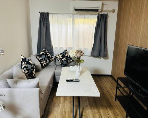 a living room with a couch and a table with flowers at takasol in Osaka