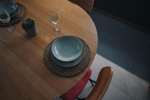 un tavolo in legno con un piatto e un bicchiere di vino di Sea Glow - Luxury Apartment a Bisceglie