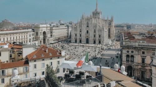 a city with a crowd of people in front of a cathedral at PRESTIGE BOUTIQUE APARTHOTEL - Piazza Duomo View in Milan