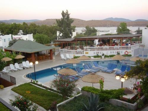 un complejo con una piscina con sillas y sombrillas en Bronze Hotel, en Gümbet