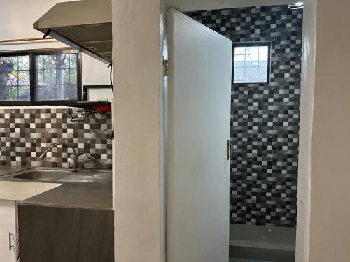 uma cozinha com um lavatório e uma bancada em House in Coron-The Grey House em Coron