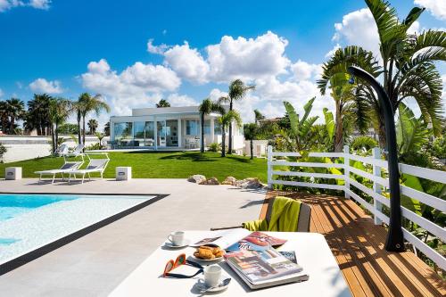 a villa with a pool and a table with food on it at Evanthe Garden - Diantha in Lido Signorino